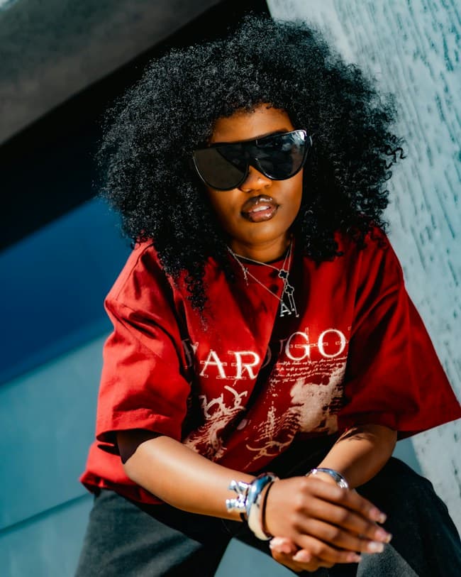 Black fashion model with an afro and sunglasses in warm sunlight