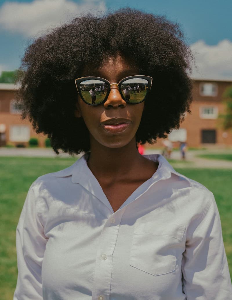 A stylish Black woman with an afro and cat-eye sunglasses